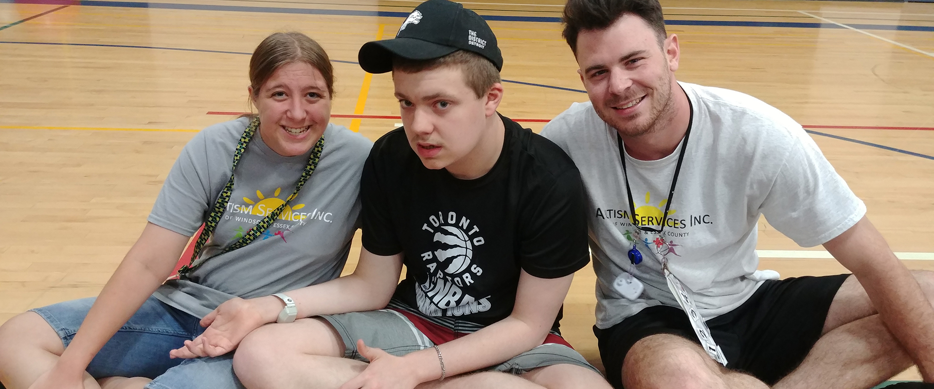 two workers sitting with boy in the gym